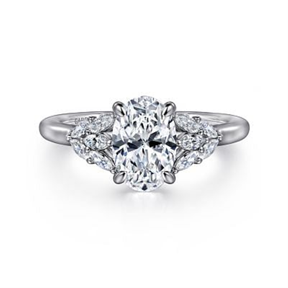 The Gabriel & Co 14K Gold Oval Diamond Engagement Ring boasts a central oval diamond with three smaller round diamonds on each side, all set in a polished band.