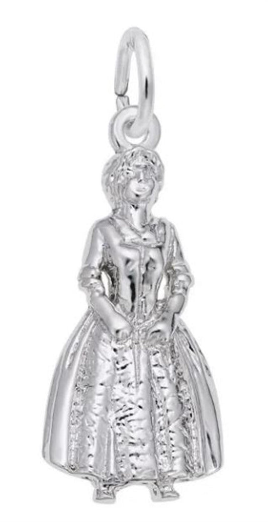 The Colonial Woman Charm in Sterling Silver, crafted by Rembrandt Charms, showcases an exquisite design featuring a colonial woman dressed in a long, intricately detailed dress with ruffled textures. Equipped with a loop at the top, it's ideal for attaching to your favorite bracelet or necklace.