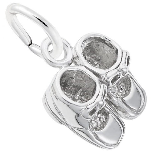 The image shows the Sterling Silver Baby Booties Accent Charm from Rembrandt Charms. The charm is crafted in sterling silver and features a pair of detailed baby booties. It measures 0.36 inches by 0.42 inches (9.1 mm x 10.59 mm) and has the style number 0516. This charm is a perfect keepsake for commemorating the early days of a new baby.