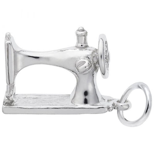 The Rembrandt Charms Sewing Machine Charm in sterling silver is intricately shaped like a vintage sewing machine, complete with detailed features such as the wheel, needle, and base. It includes a small loop on one end for easy attachment to a bracelet or necklace. The polished, reflective surface enhances its shiny metal appearance.