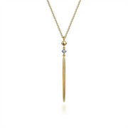 The 14K Yellow Gold Diamond Pendant Drop Necklace by Gabriel & Co features a long, slender diamond pendant in 14K yellow gold, accented with a small geometric gold shape above it. The pendant gracefully hangs from a delicate gold chain, epitomizing an elegant and minimalist modern design aesthetic.