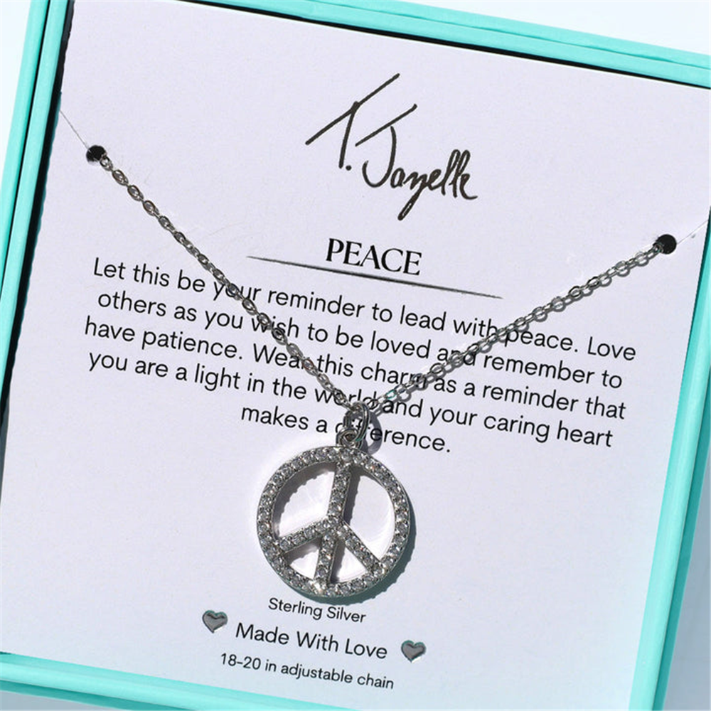 The T Jazelle Peace CZ Sterling Silver Charm Necklace features an adjustable sterling silver peace charm on a message card, presented in a turquoise box for lasting beauty.