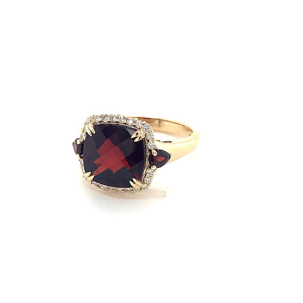 The Large Garnet and Diamonds Ring by Bellarri is a stunning 14K yellow gold piece, featuring a large, square-cut red garnet as the centerpiece. This exquisite garnet is bordered by small, clear diamonds and flanked by two smaller red stones on either side. The band completes the design with its plain gold elegance.
