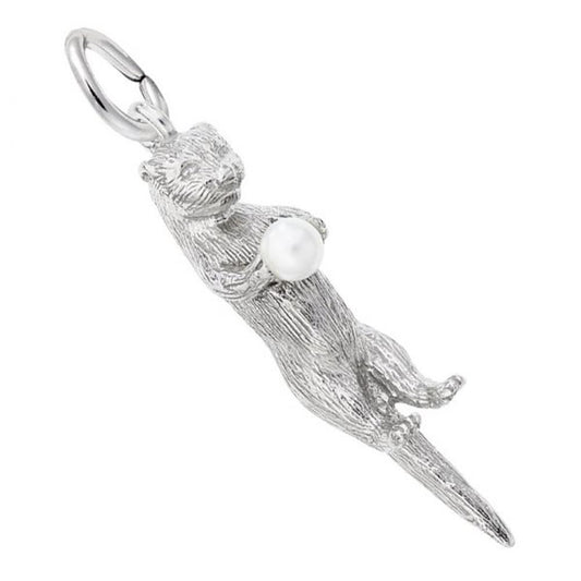 The Rembrandt Charms Sea Otter Charm, crafted in sterling silver, features an otter-shaped pendant holding a small pearl in its front paws. The charm includes a loop at the top for attaching to a chain or necklace. The sea otter is depicted in a playful pose with detailed fur texture.
