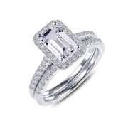 Introducing the Emerald-Cut Halo Wedding Set Size 7 by Lafonn: this exquisite set features a captivating emerald-cut center stone encircled by a halo of dazzling diamonds. The set is complemented by a matching silver wedding band, elegantly adorned with small diamonds for an added touch of sophistication and sparkle.