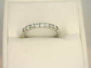 The 14K White Gold .32cts Round Cut Diamond Anniversary Band from Benchmark Rings is displayed in a white jewelry box. The anniversary band stands out against the soft white background, highlighting its elegant and simple design.