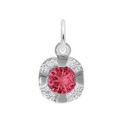 The Rembrandt Charms Petite Birthstone - July Charm in sterling silver features a circular pendant with a pink, faceted gemstone at the center. Surrounded by a shiny, petal-like metallic frame, this charm is perfect for celebrating a July birthstone. It includes a small loop at the top for easily attaching to a chain.