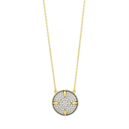 The Freida Rothman Petals and Pavé Small Pendant Necklace, with its delicate chain and pavé accents, captures the elegance of the Brooklyn Skyline through a round gold pendant adorned with small sparkling stones and petal-like arrangements.