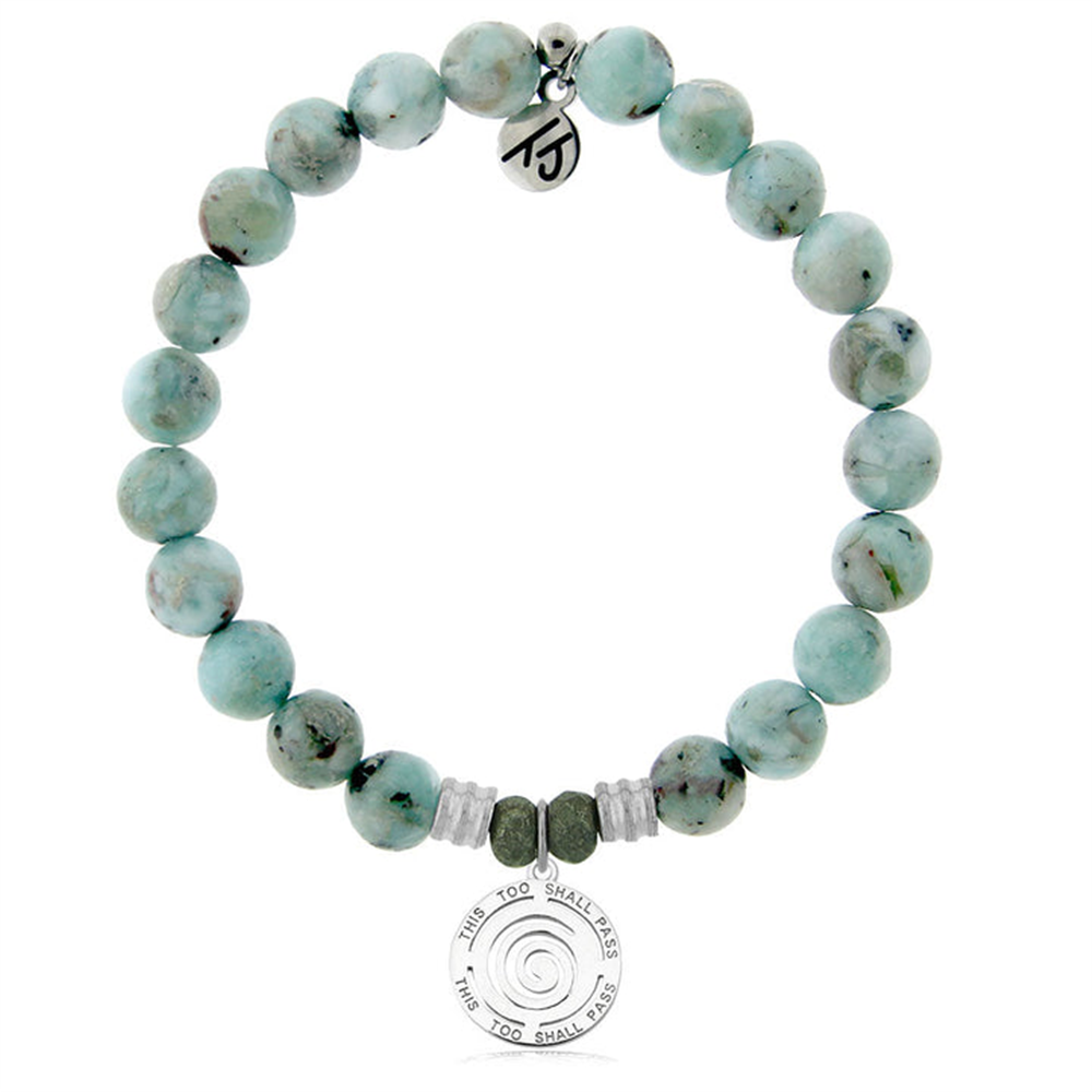 The T Jazelle Larimar Gemstone Bracelet features light blue-green stones, silver and green accents, plus two sterling silver charms—one engraved with a spiral and "This Too Shall Pass," the other with a unique symbol.