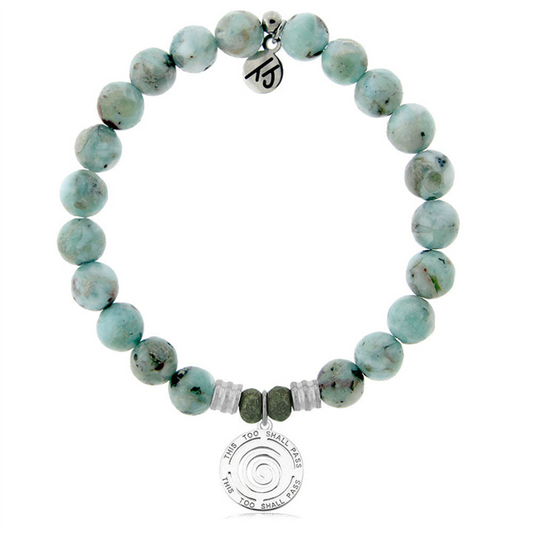 The T Jazelle Larimar Gemstone Bracelet features light blue-green stones, silver and green accents, plus two sterling silver charms—one engraved with a spiral and "This Too Shall Pass," the other with a unique symbol.