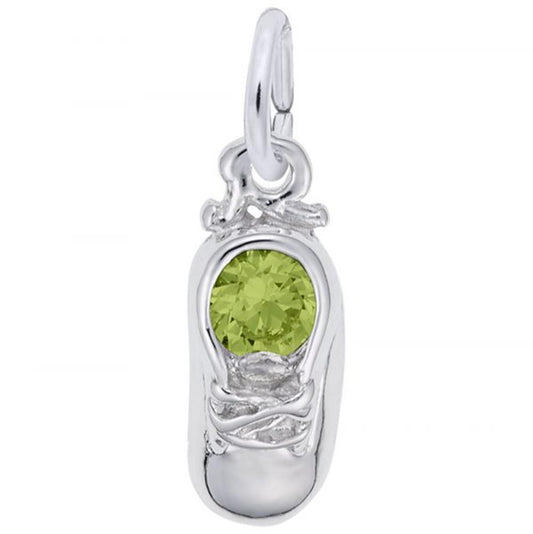 The August Baby Shoe Charm / Sterling Silver by Rembrandt Charms is crafted in sterling silver and adorned with a round, green gemstone set in the center. This charming piece features a small loop at the top, perfect for attaching to a bracelet or necklace.