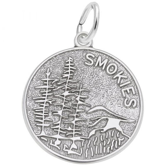 The Smokies Charm from Rembrandt Charms is a round sterling silver piece featuring an engraved design of trees, mountains, and the word "SMOKIES." It includes a small loop at the top for attaching to a chain or bracelet.