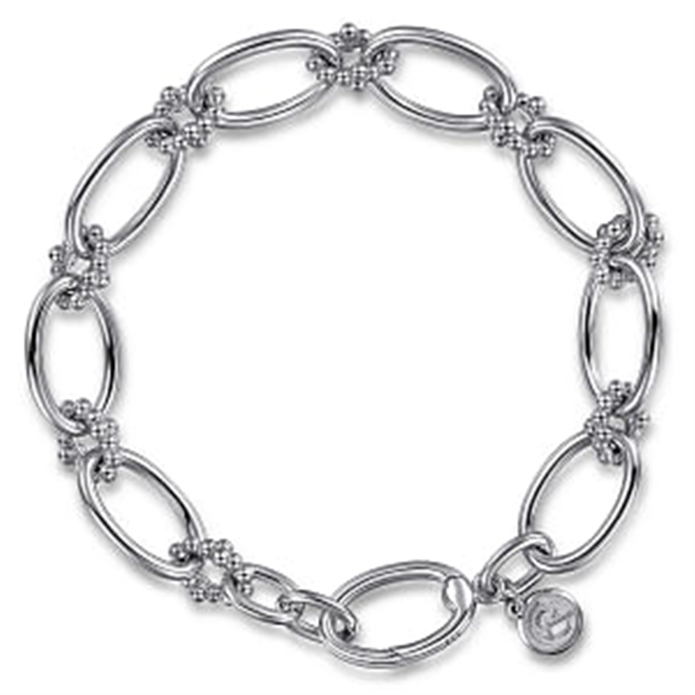 The Gabriel & Co Sterling Silver Bujukan Link Bracelet | 7" features large, elongated oval links intricately connected by smaller decorative elements. A small circular charm with an engraved design hangs near the clasp, adding a unique touch. This exquisite piece, part of the Bujukan Collection, is crafted in 925 silver.