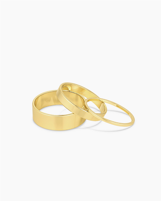 Three 18k gold plated rings of varying thickness from Gorjana's Rose Ring Set are arranged on a plain white background. This smooth, shiny set is available in size 7.