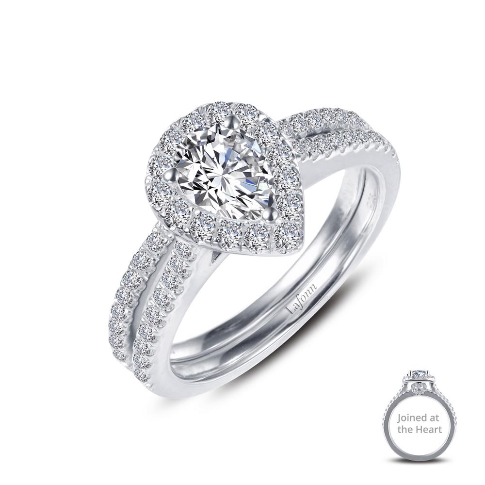 The "Joined-At-The-Heart Wedding Ring" by Lafonn is a stunning engagement piece crafted in silver. It features a prominent pear-shaped central diamond, encircled by a halo of smaller diamonds. The band is elegantly adorned with additional small diamonds for added sparkle. A close-up inset showcases its delicate details labeled "Joined at the Heart." This exquisite wedding ring exudes elegance and brilliance, making it perfect for your special day.