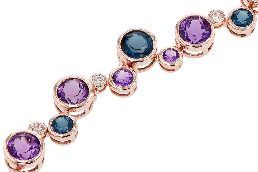 The "Semi-Precious and Diamond 14k Rose Gold Bracelet" by Allison Kaufman offers a touch of elegance with its modern and sophisticated design, showcasing semi-precious gemstones in an array of sizes and colors, including purple, blue, and small clear stones.