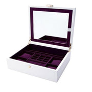 A white Vahan Jewelry Box by Alwand Vahan Jewelry, featuring a built-in mirror in the lid and lined with luxurious purple velvet. It incorporates innovative LusterLoc technology and offers various compartments of different sizes for storing jewelry items when opened.