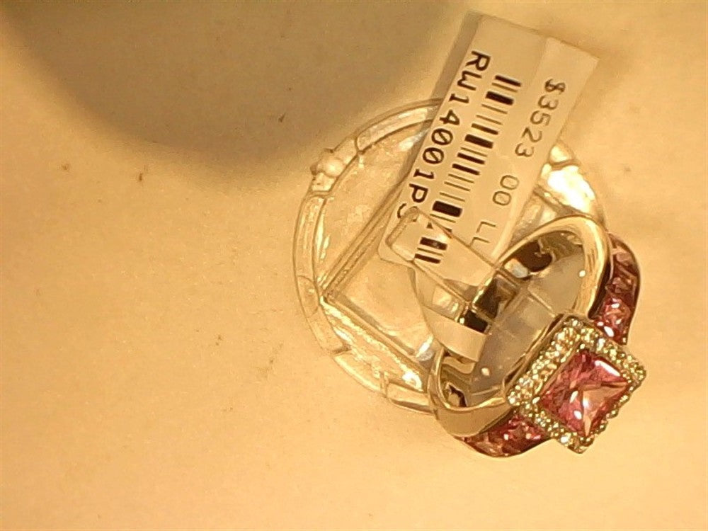 The Ryan Gems Diamond and Pink Sapphire Channel Set Ring features sparkling diamonds and pink sapphires in 14k white gold, size 6.5, displayed on a clear stand with a white price tag attached.