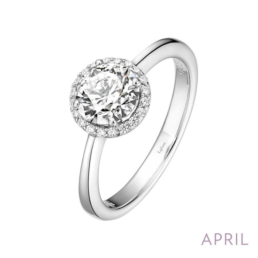 The April Birthstone Ring from Lafonn features a sleek silver band with a stunning round-cut diamond at its center, encircled by smaller diamonds in a halo setting. The text "APRIL" is prominently displayed in the lower-right corner, making it an ideal choice for those celebrating their birthday in April.
