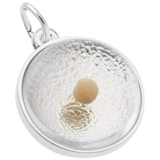 A round sterling silver pendant features a clear, textured surface with a central beige spherical bead resembling a mustard seed. This charming accessory, the Mustard Seed Charm / Sterling Silver by Rembrandt Charms, includes a loop at the top for attaching to a chain or string.