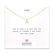 A delicate gold-plated sterling silver chain necklace with a petite wishbone charm, displayed on a white card. The card features "WISH" at the top and the inspiring message "DON'T BE AFRAID TO BE BOLD! WEAR YOUR NECKLACE AS A REMINDER TO WISH WITHOUT LIMITS... MAKE IT COUNT!" This timeless piece from Dogeared is ideal for those who believe in boundless possibilities. Product name: Wish/ GP-SS.
