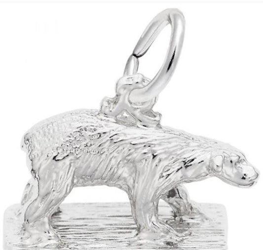 The Polar Bear Charm from Rembrandt Charms is crafted in sterling silver and depicts a polar bear standing on a textured surface. This charming piece features a small loop on its back for easy attachment to a chain or necklace. The detailed design beautifully highlights the bear's fur and form.
