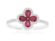 Introducing the Royal Jewelry 14k WG Ruby and Diamond Ring in size 6.75, this stunning piece features a captivating four-petal flower design. The petals are elegantly adorned with pear-shaped ruby gemstones and surrounded by small, clear stones extending to the band. Crafted from luxurious 14k white gold, it offers a sophisticated silver sheen that enhances its exquisite charm.