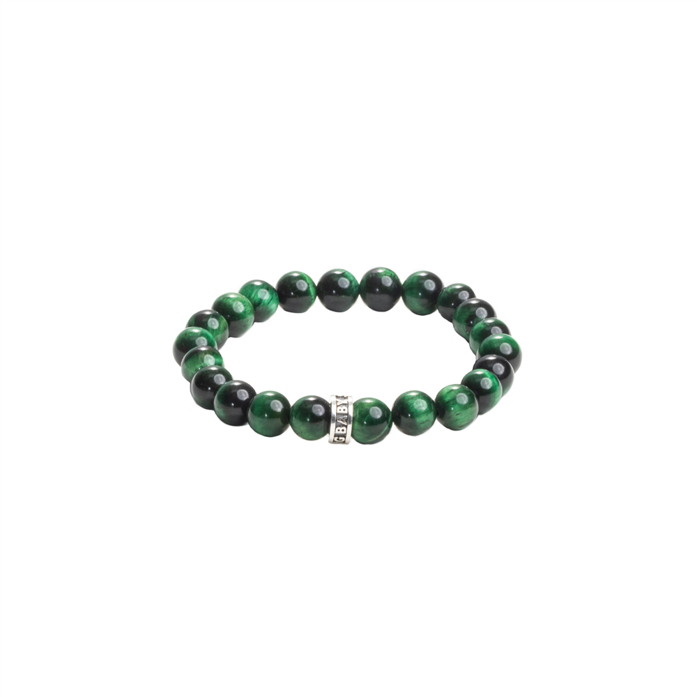 The King Baby bracelet features 10mm green tiger eye and black beads with a metallic charm engraved with a logo ring at the center, all polished and evenly spaced on an elastic band against a plain white background.