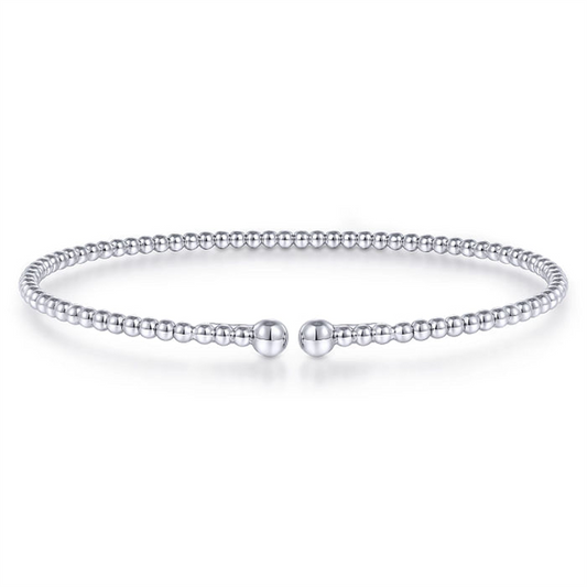 A delicate beaded bracelet with a minimalist design, featuring evenly spaced small round beads. The Gabriel & Co 14K White Gold Bujukan Split Bangle, sized at 6.25, is circular and appears to be flexible, with a gap at the front held by two slightly larger bead ends. The background is white and plain.