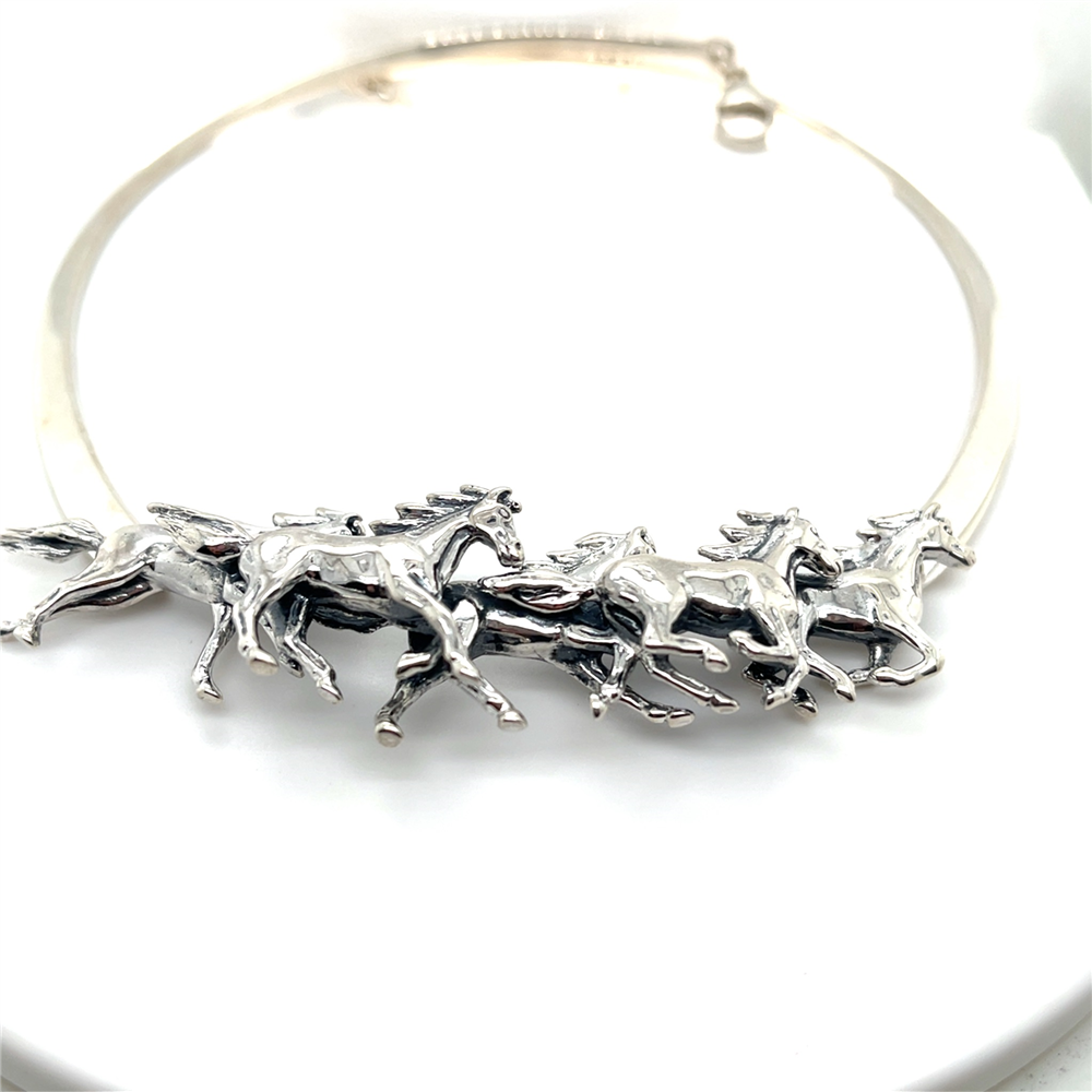 Kabana’s SS Collar Necklace features 5 running horses crafted from heavy forged wires, capturing dynamic motion in silver against a white backdrop.
