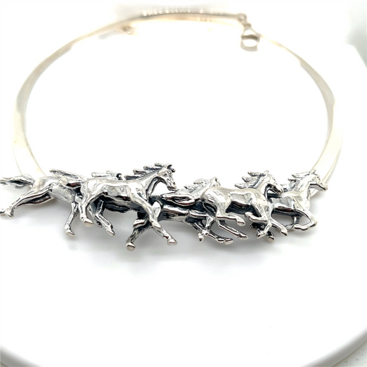Kabana’s SS Collar Necklace features 5 running horses crafted from heavy forged wires, capturing dynamic motion in silver against a white backdrop.