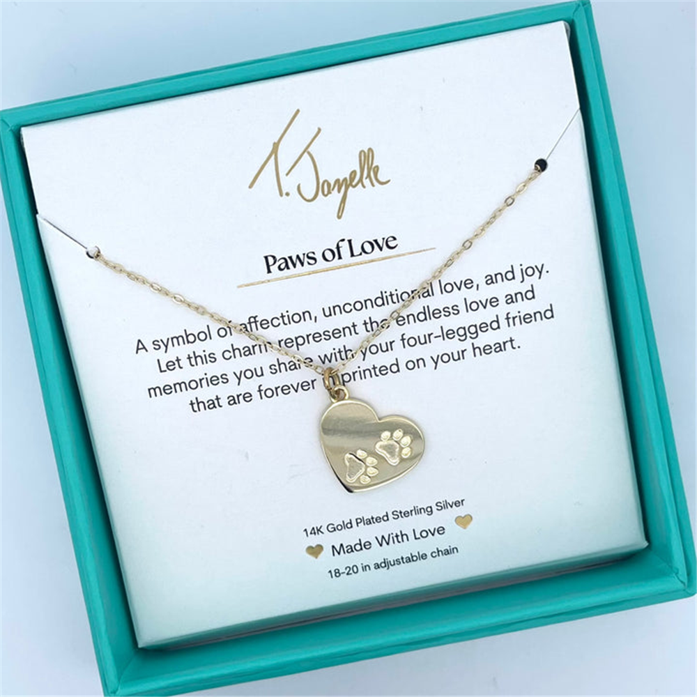 The Paws of Love Gold Charm Necklace by T Jazelle features heart and paw prints in a teal box with a "Paws of Love" card, symbolizing affection for your four-legged friend.
