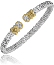 A beautifully crafted Alwand Vahan Jewelry bracelet made of 14k gold and sterling silver, showcasing intricate circular patterns. The bracelet features two ornate 14k gold accents, each adorned with a central round diamond weighing a total of 0.11 carats. This slightly curved 4mm band has a reflective surface beneath the intricate design.
