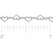The Polished Heart Sterling Silver chain by Stuller-Stuller, featuring intricately shaped heart links each less than an inch wide, is showcased against a pristine white background, highlighting its delicate elegance.