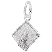 The Graduation Cap Small Charm by Rembrandt Charms is crafted from sterling silver. This elegant piece, designed in the shape of a textured graduation cap, features a loop at the top for easy attachment to a bracelet or necklace and showcases a detailed tassel design on one side.