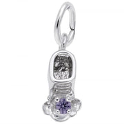 A close-up image of Rembrandt Charms' June Baby Bootie Charm in sterling silver, adorned with a purple gemstone on top. This charm features a loop at the top for attaching to a bracelet or necklace, and boasts intricate detailing including laces and texture on the inside.