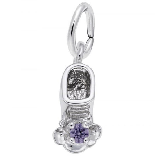 A close-up image of Rembrandt Charms' June Baby Bootie Charm in sterling silver, adorned with a purple gemstone on top. This charm features a loop at the top for attaching to a bracelet or necklace, and boasts intricate detailing including laces and texture on the inside.