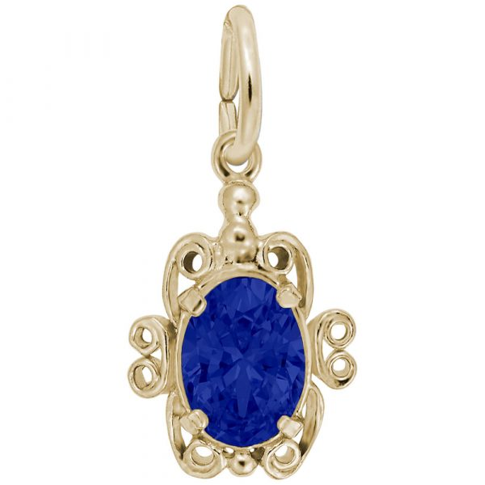 The Filigree September Birthstone Charm from Rembrandt Charms is a gold-plated sterling silver pendant featuring an intricate filigree design that surrounds an oval-cut, deep blue September stone in the center, with a small loop at the top for attaching to a chain.