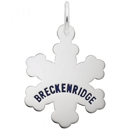 The Rembrandt Charms Breckenridge Snowflake Charm, crafted from sterling silver, displays the word "BRECKENRIDGE" in striking blue capital letters across its center. This elegant pendant also features a small loop at the top for easy attachment to a chain or string.