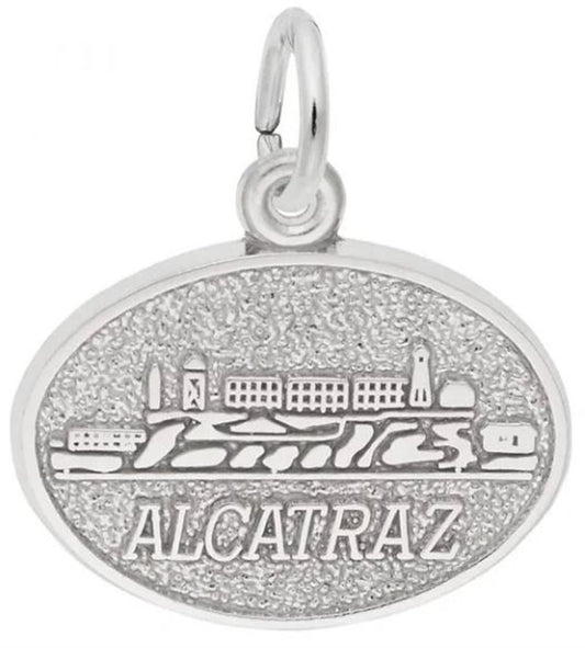 Sterling silver Alcatraz Oval Disc charm by Rembrandt Charms, featuring an engraved depiction of Alcatraz Island and the word "ALCATRAZ" below, with a small loop for attachment. Dimensions: 0.72 in x 0.53 in (18.2 mm x 13.53 mm).