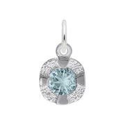 The Petite Birthstone - March Charm by Rembrandt Charms is crafted from sterling silver and features a light blue round birthstone at its center. The gemstone is enclosed within a square, textured border, and the charm includes a small loop at the top for easy attachment to a chain or bracelet.