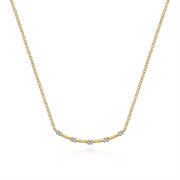 The Gabriel & Co 14k yellow gold diamond station bar necklace from our Contemporary Collection features a delicate chain with a curved bar pendant. It is adorned with five evenly spaced, small white gemstones, creating a simple yet elegant design that highlights the shimmer of the stones and gold's warmth.