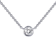A close-up image of the 1/2 Carat Diamond Solitaire Necklace by Lafonn showcases a delicate sterling silver chain and a single round-cut simulated diamond pendant set in a simple bezel. The necklace boasts a minimalist and elegant design.