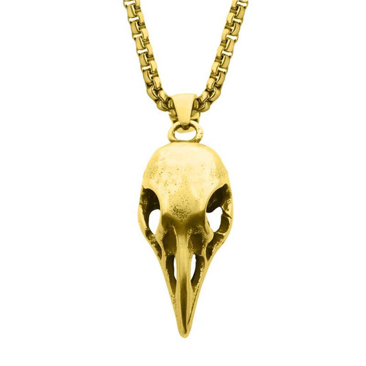 The Distressed Matte 18Kt Gold IP Crow Skull Pendant with Chain from INOX features a pendant shaped like a bird's beak and eye sockets, symbolizing the power of change. The detailed carvings highlight its uniqueness, while the 18Kt gold chain boasts an elegant box chain design.