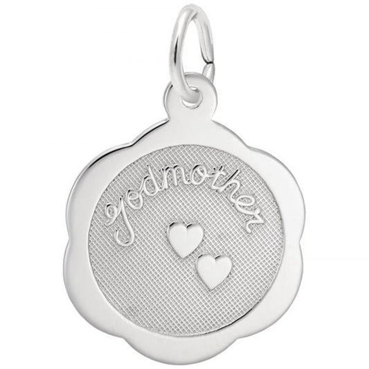 The Rembrandt Charms Godmother Scalloped Disc Charm in sterling silver features the word "godmother" engraved on a textured circular surface, adorned with two small engraved hearts below the text. The pendant is designed with a scalloped edge and includes a loop at the top for easy attachment to a chain or necklace.