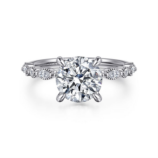The Gabriel & Co 14K White Gold Round Diamond Engagement Ring, head size 7.4 and ring size 6.5, features a large round center diamond with smaller round and marquise diamonds along the band, shown on a white background.