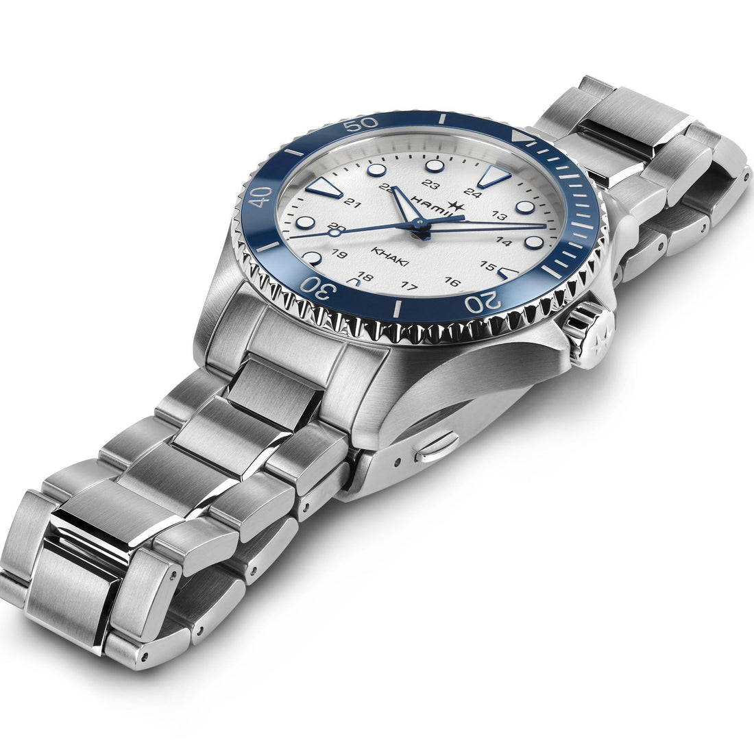 A sleek, silver stainless-steel wristwatch with a blue bezel and a white dial, reminiscent of high-seas style. The Hamilton Khaki Navy Scuba Quartz 37mm features luminous hands and markers, a date window, and a metal link bracelet. The bezel includes minute markers up to 50, showcasing its polished, robust design.