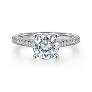 The Gabriel & Co 14K White Gold Round Diamond Engagement Ring features a 1.50 carat brilliant-cut center in a four-prong setting, accented with smaller diamonds along the band for an elegant, timeless look.