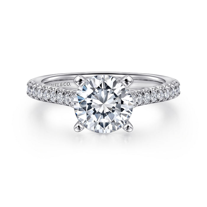 The Gabriel & Co 14K White Gold Round Diamond Engagement Ring features a 1.50 carat brilliant-cut center in a four-prong setting, accented with smaller diamonds along the band for an elegant, timeless look.