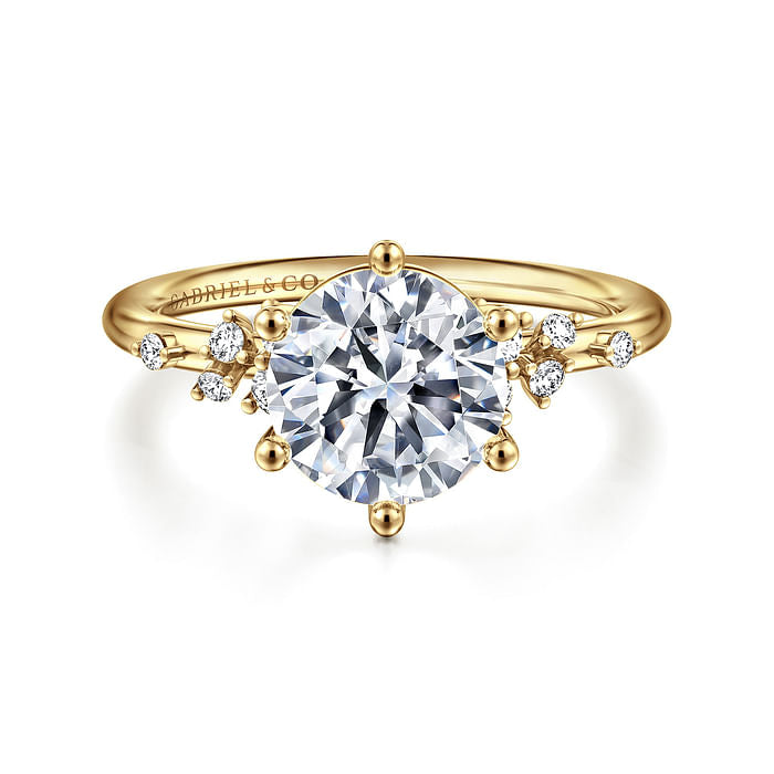 The Gabriel & Co 14K Y floral band engagement ring features a large round diamond center stone with smaller diamond accents in a delicate nature-inspired design.